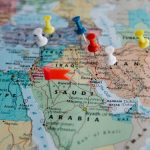 Colorful pushpins mark locations on a map of the Middle East, highlighting travel plans.